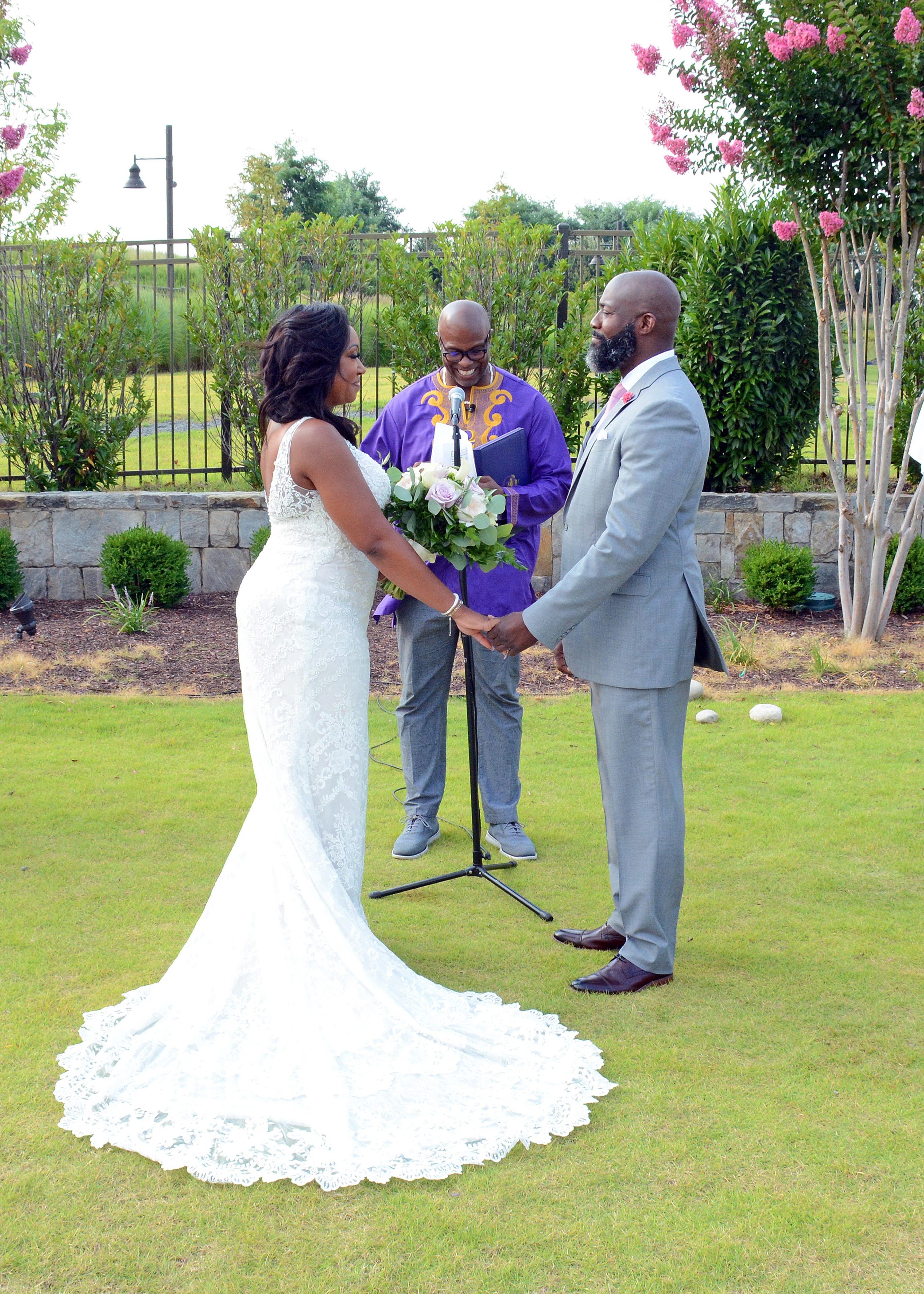 Bride and groom exchanging vows at an outdoor garden wedding ceremony