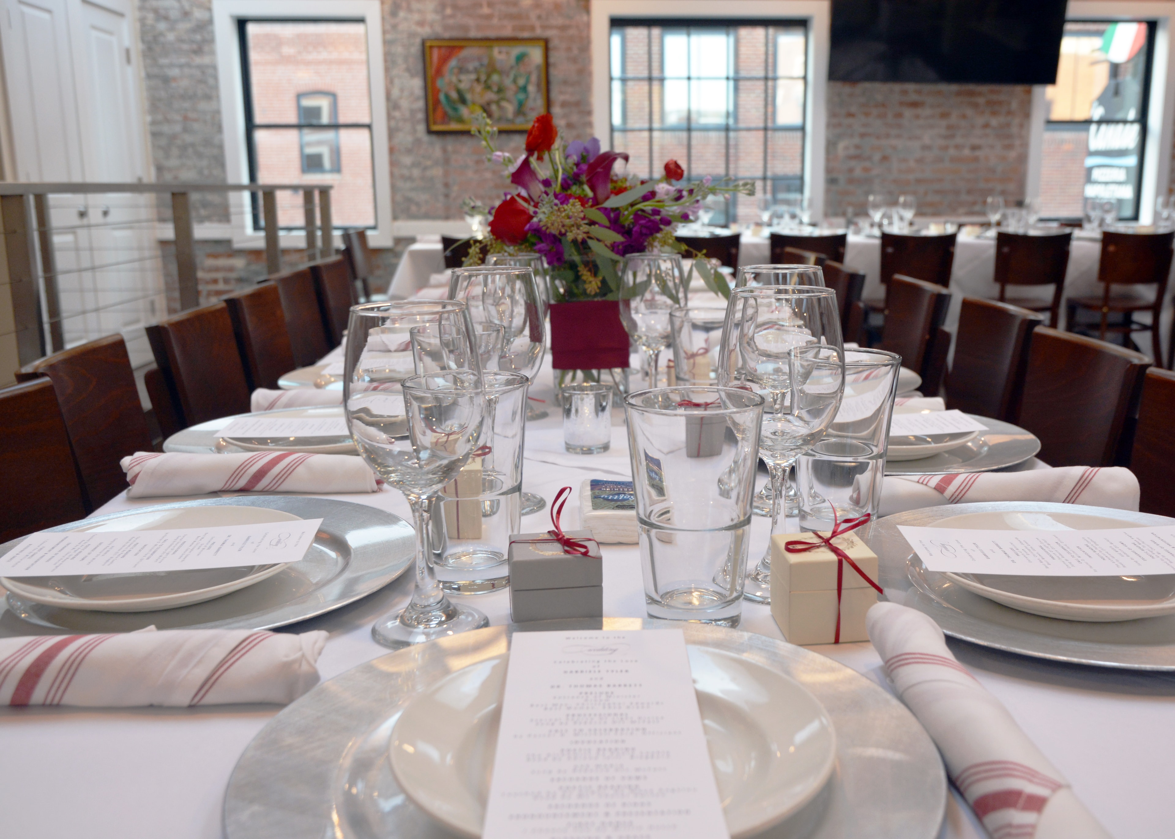 Elegantly set wedding reception dining table with floral centerpiece and place settings